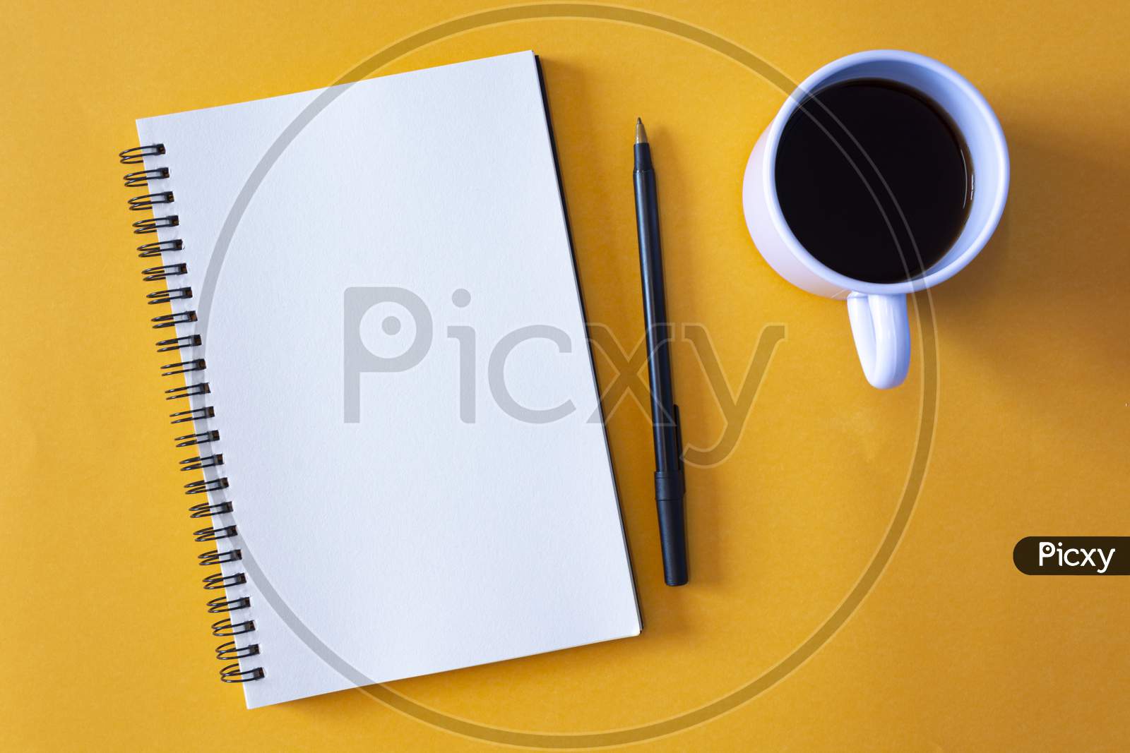 Notepad With Pen And A Cup Of Coffee On Yellow Background
