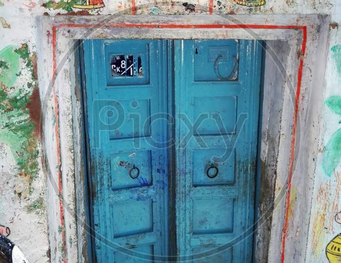 A Decorative Blue Door Gate Of Local Residence In Narrow Alley Between Colourful Houses In Varanasi, India. The Old City Of Varanasi Is A Network Of Narrow Alleys Which Cars Cannot Fit Through.