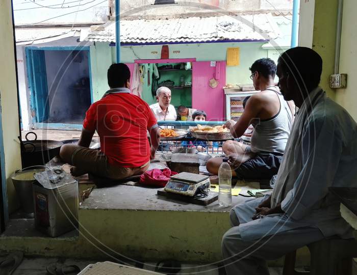 Varanasi, India - November 01, 2016: Interior Scene Of Traditional Snacks Such As Jalebi And Poori Makers Prepare Street Break Fast In Famous Kachodi Gali With Customer As Old Man And Kid Buying It