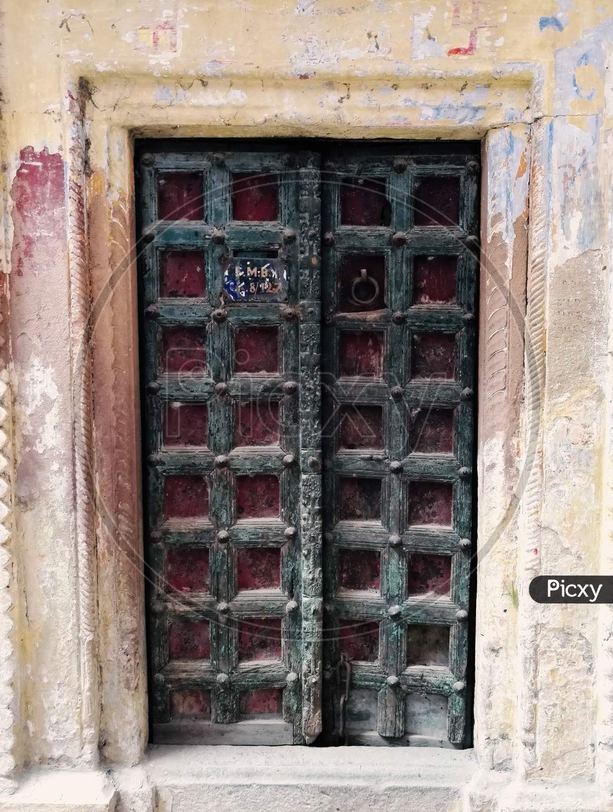 A Decorative Dark Color Door Gate With Square Pattern Design Of Local Residence In Narrow Alley Between Colourful Houses In Varanasi, India.