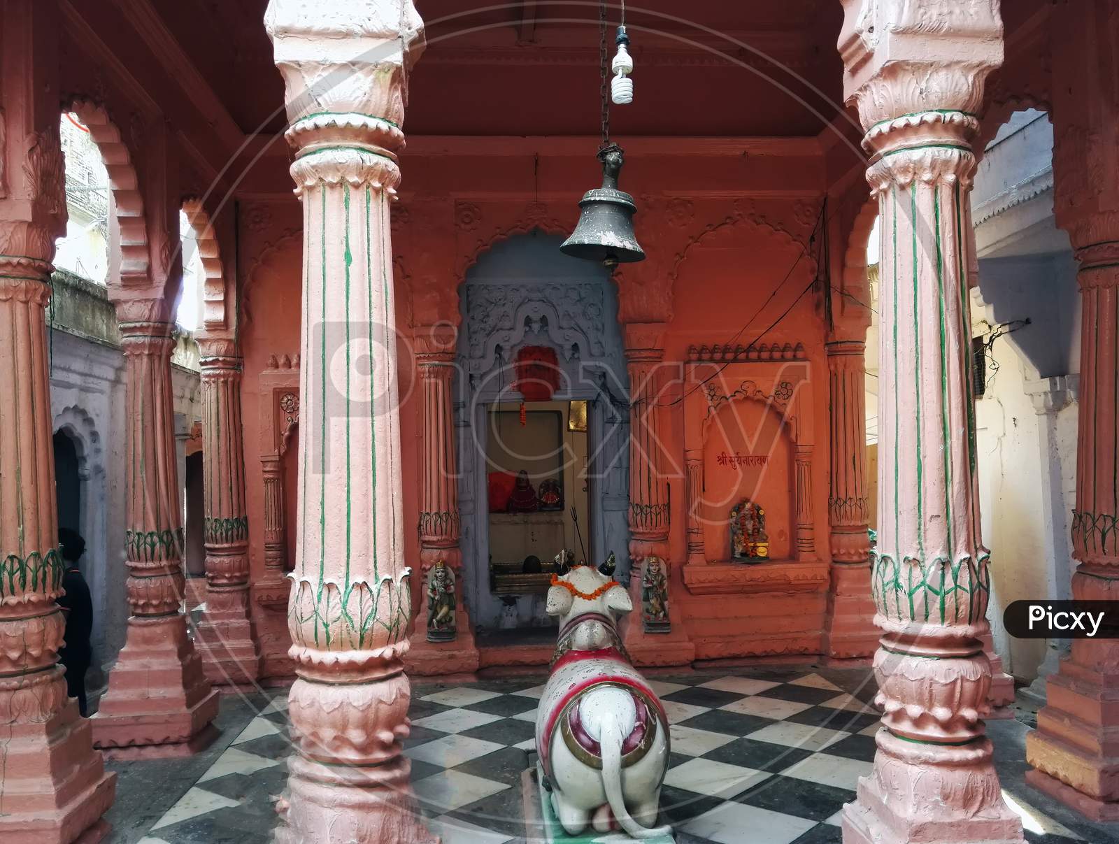 Varanasi, India - November 01, 2016: Interior Of A Hindu Temple With Pillars, Stone Diety Bull Nandi And Bell Swinging On Top. Uttar Pradesh.