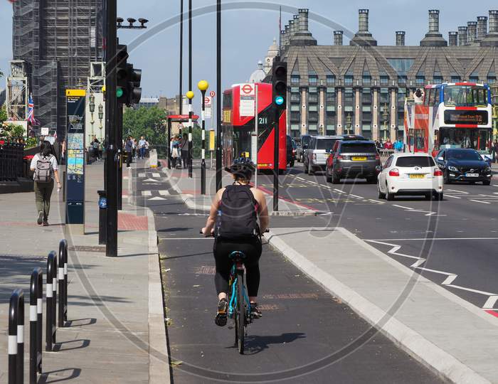 London, Uk - Circa June 2018: View Of The City With Woman Cycling On Westminster Bridge