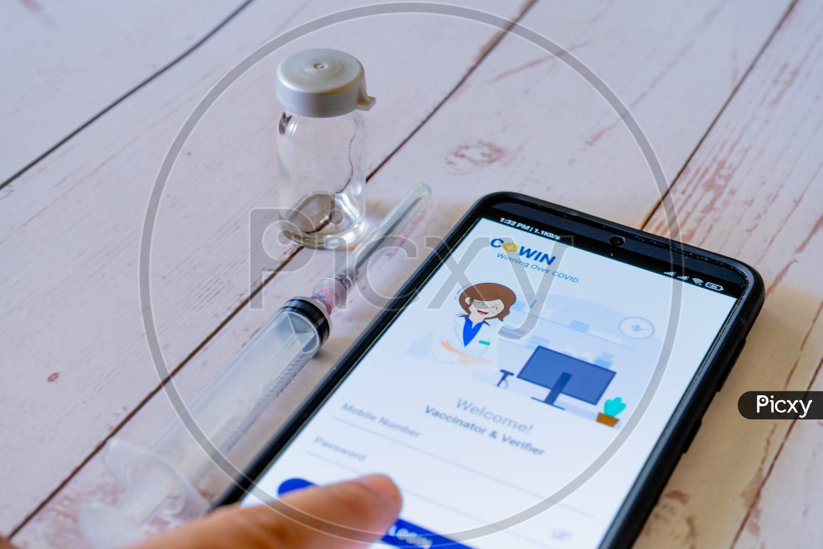 Man Doctor Pointing To Co-Win App Application While Getting Vaccinated With A Syringe And Vial As Covaxin Covishield Is Administered During The Covid19 Coronavirus Pandemic In India Asia