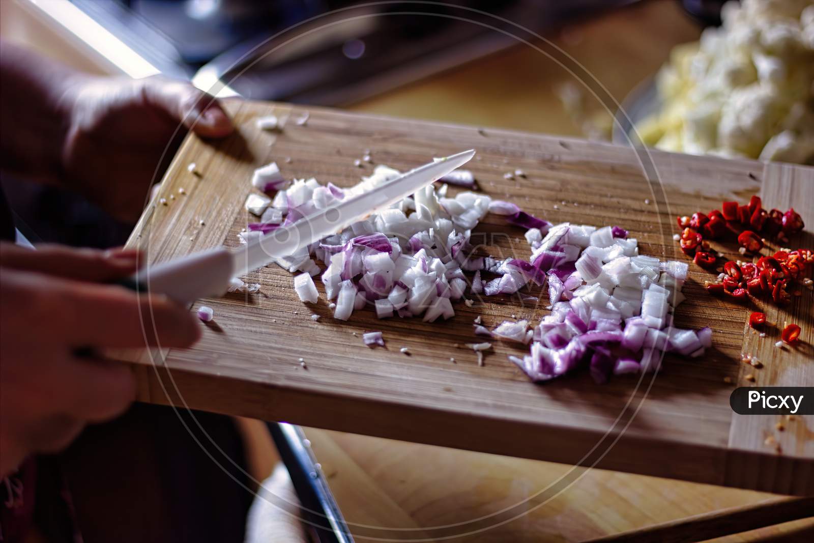 A Hands Slicing Onion And Chilli On Wooden Cutting Board, Indian Asian Spicy Home Cooking Concept