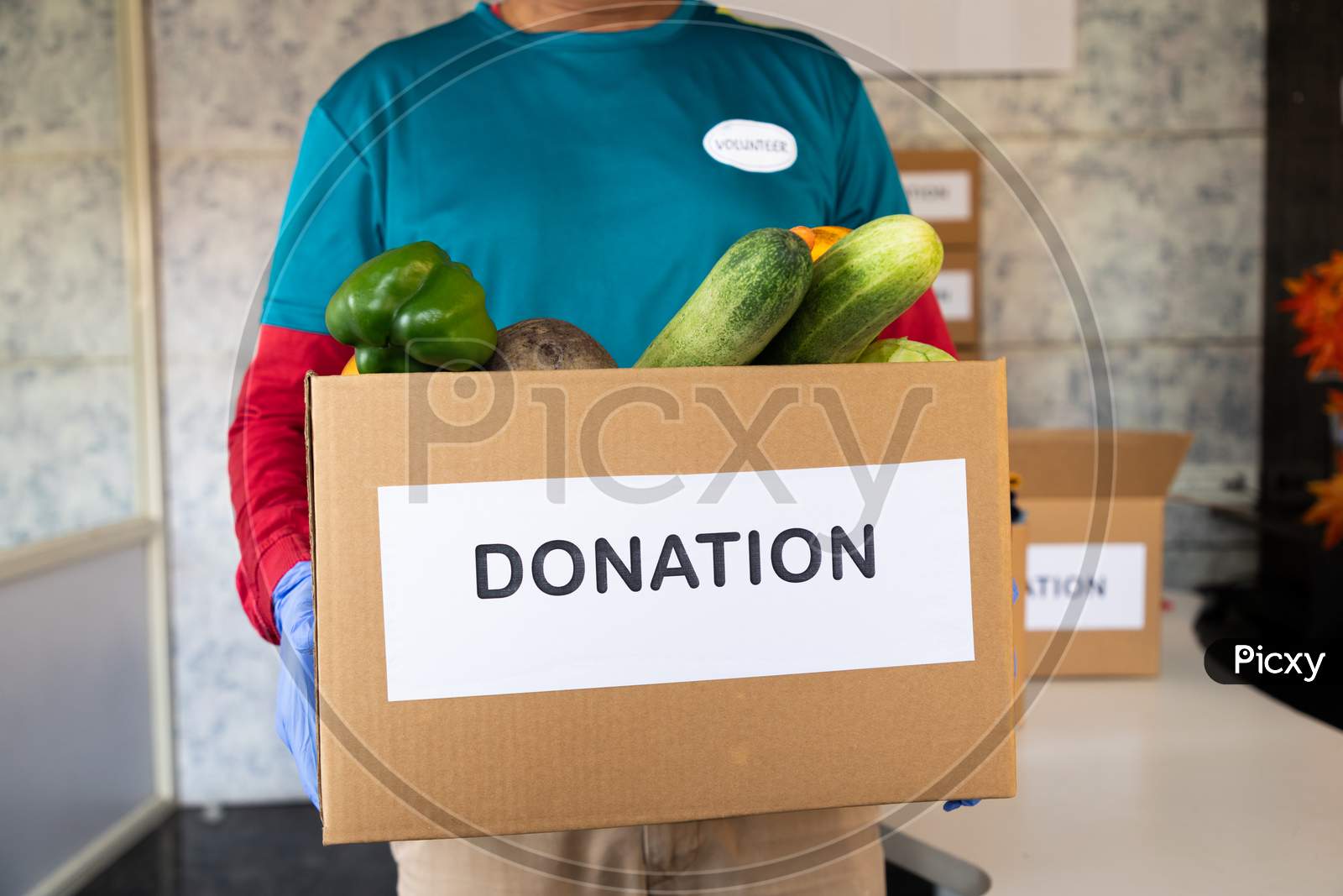 Unrecognizable Volunteer Holding Donation Box With Vegetables - Concept Of People Volunteering To Help Others During Coronavirus Covid-19 Pandemic Lockdown.