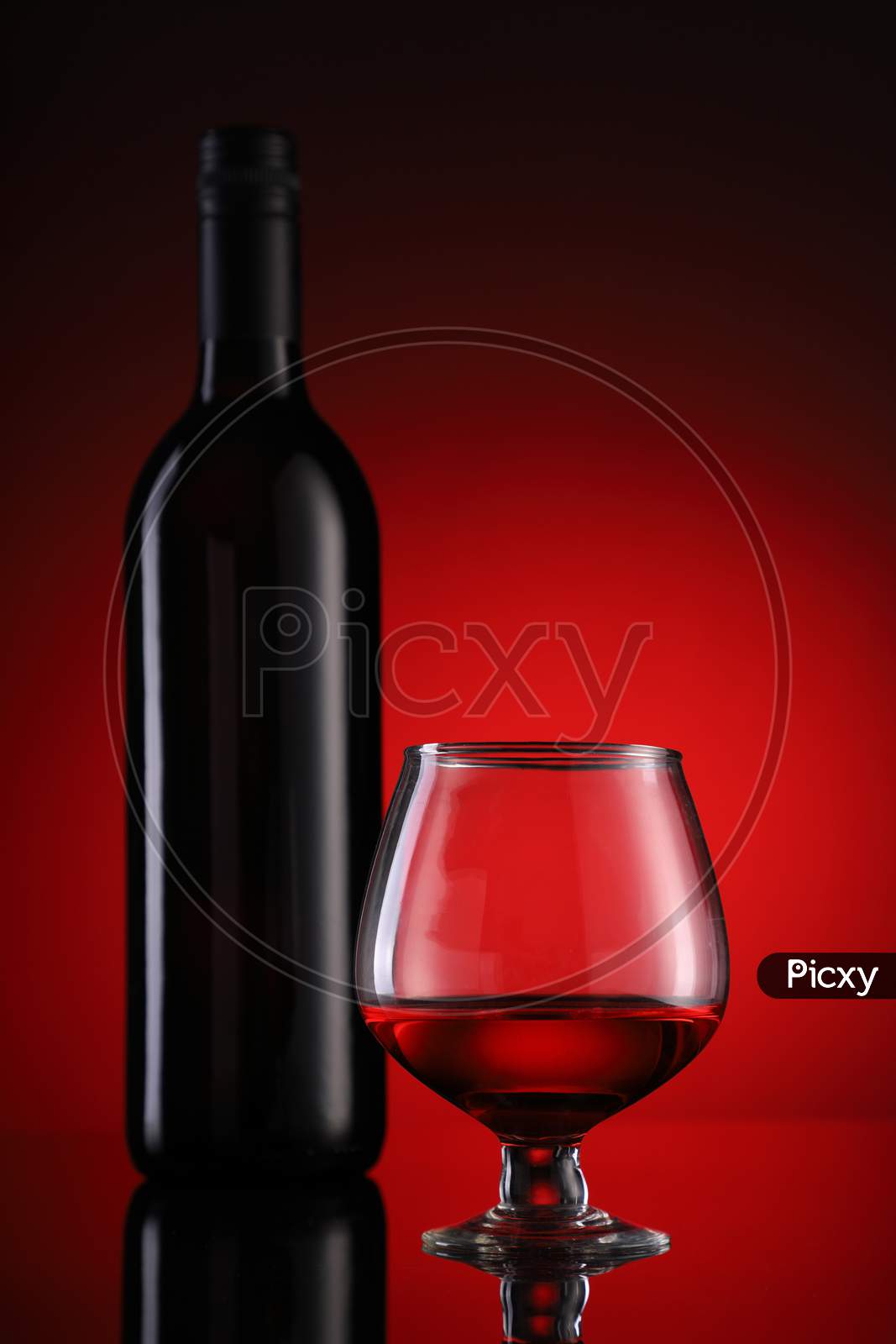 Red Wine Glass And Bottle On Red Background