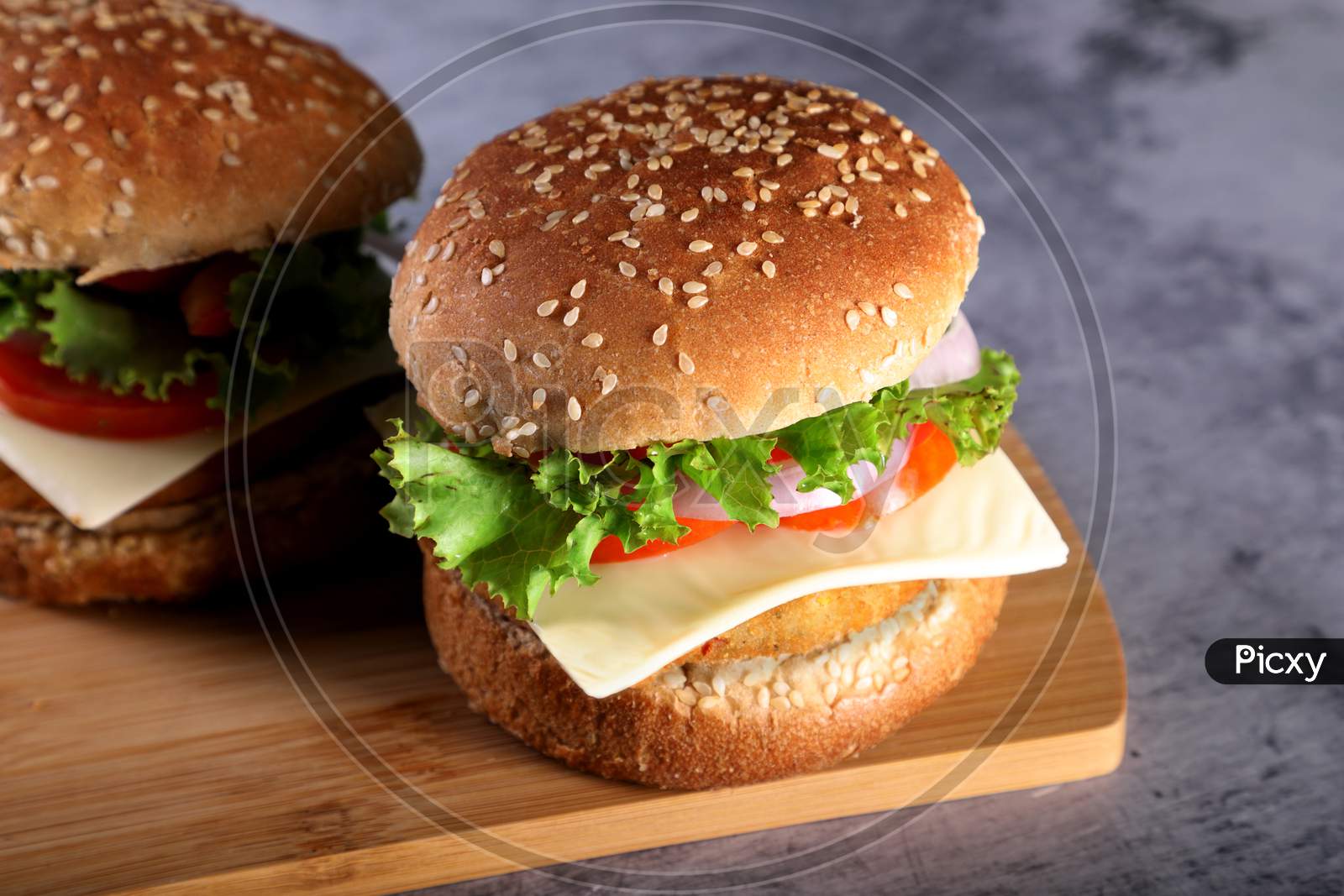 Fast Food - Burgers On A Wooden Mat With Textured Background