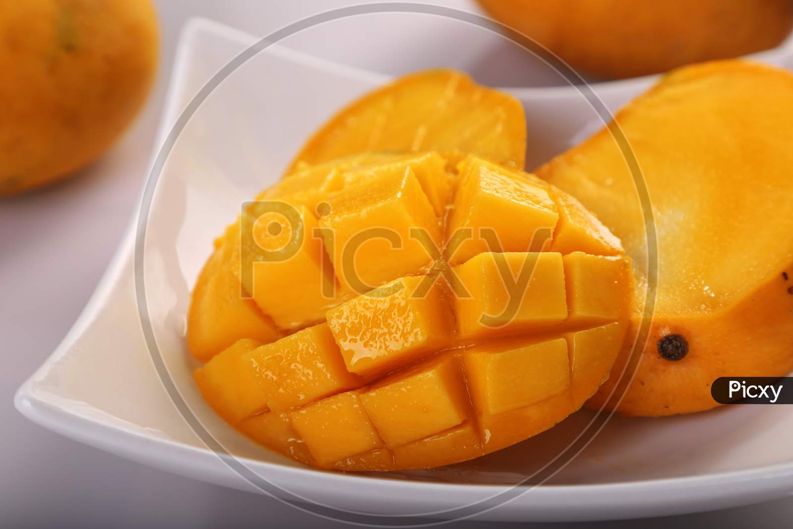 Fresh Organic Mango Fruit Sliced In A White Plate