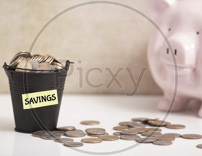 Saving Coins In A Bucket And Piggy Bank
