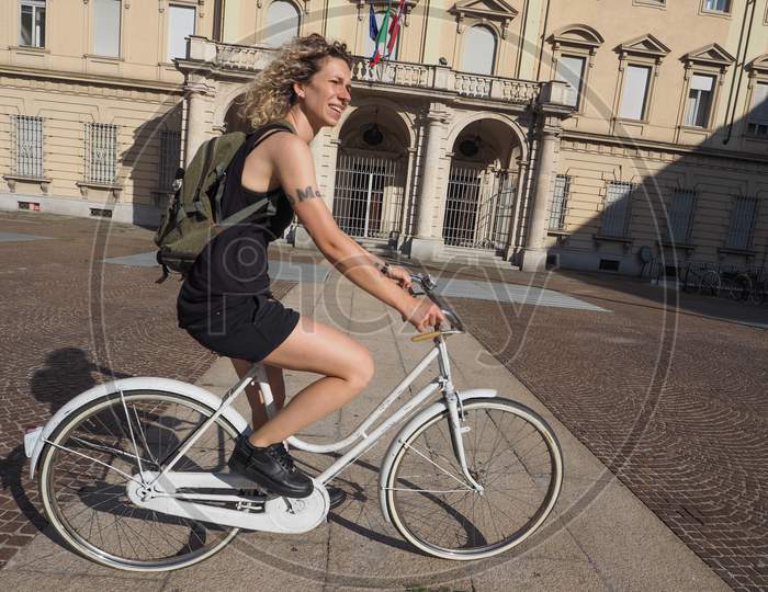 Turin, Italy - Circa August 2017: Beautiful Cyclist Woman On A White Bicycle In The City Centre