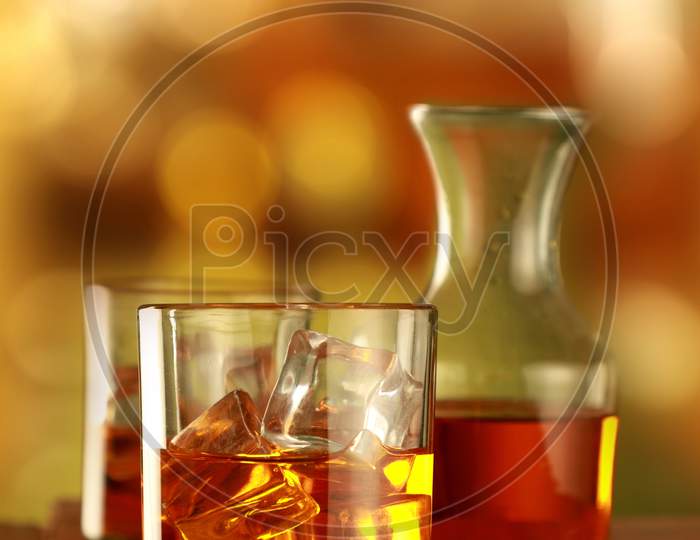 Chilled Whisky Glass With Ice Cubes On Blurred Background