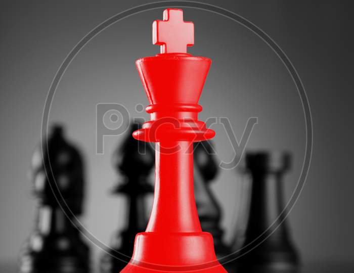 Leadership Red Chess King With Pieces On Dark Background