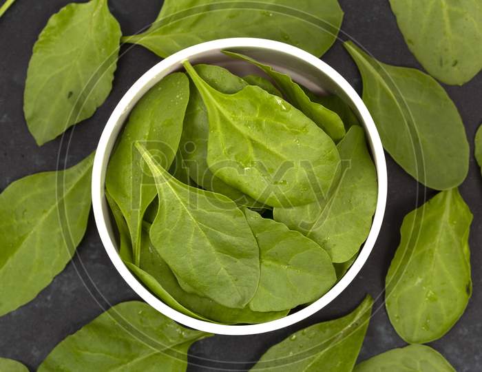 Spinach Leafs In Bowl On Wooden Background