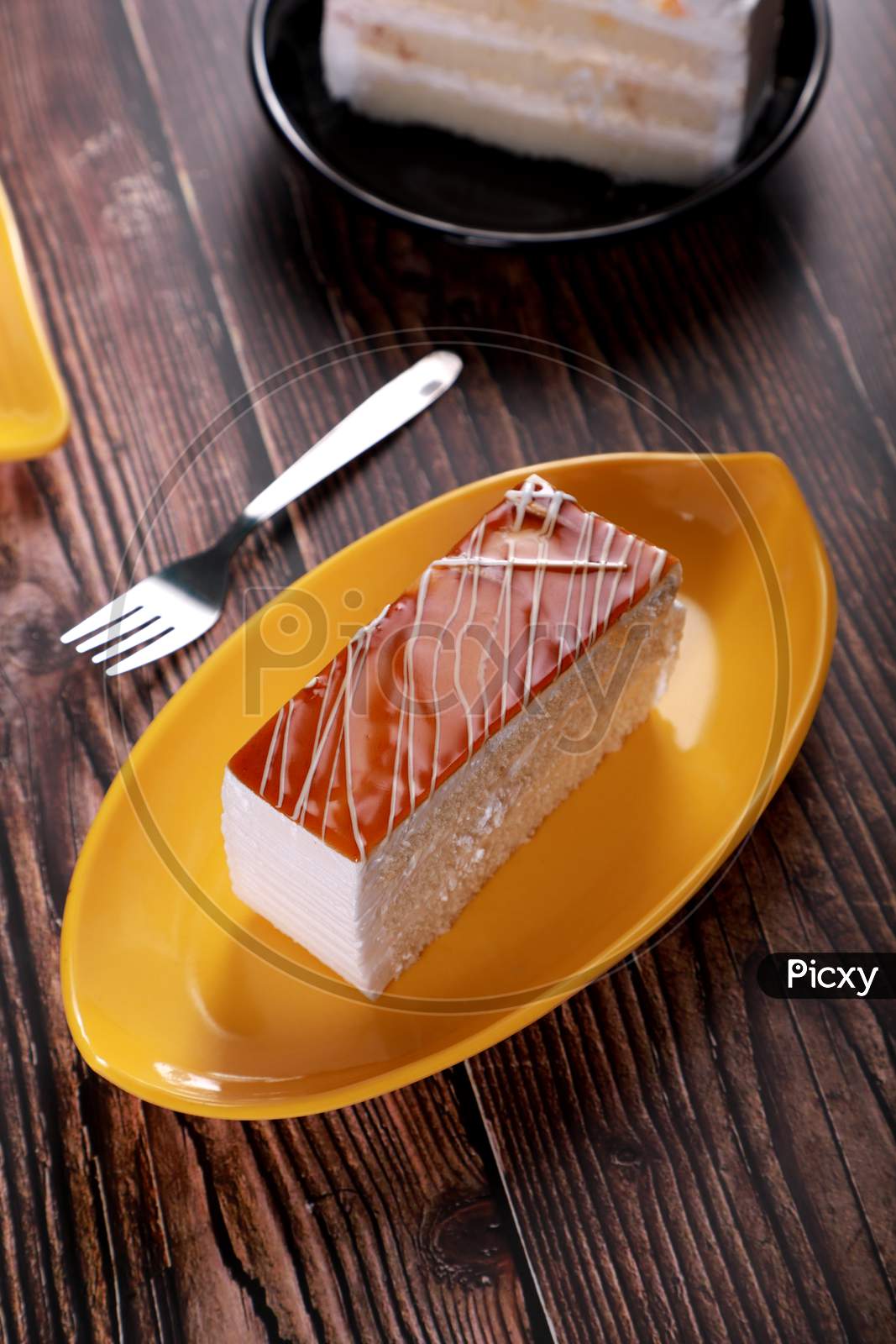 Caramel Pastry Cheese Cake On A Yellow Plate With Fork On Wooden Table