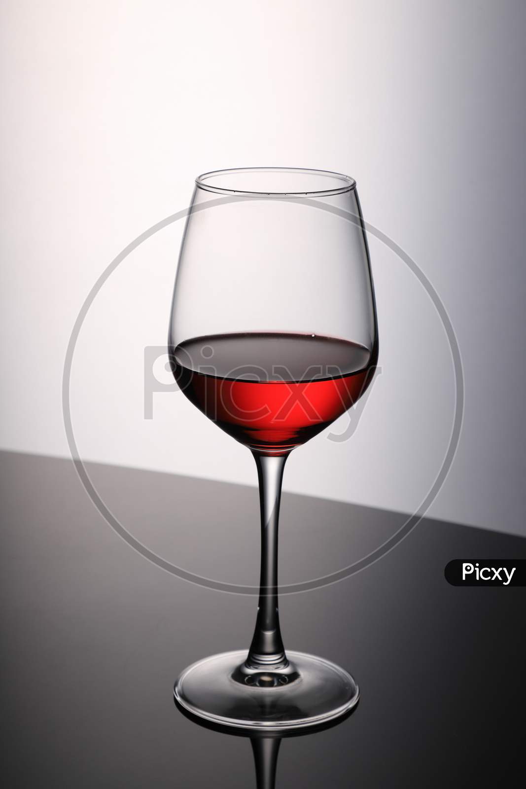 Red Wine Glass On Black Table And White Background