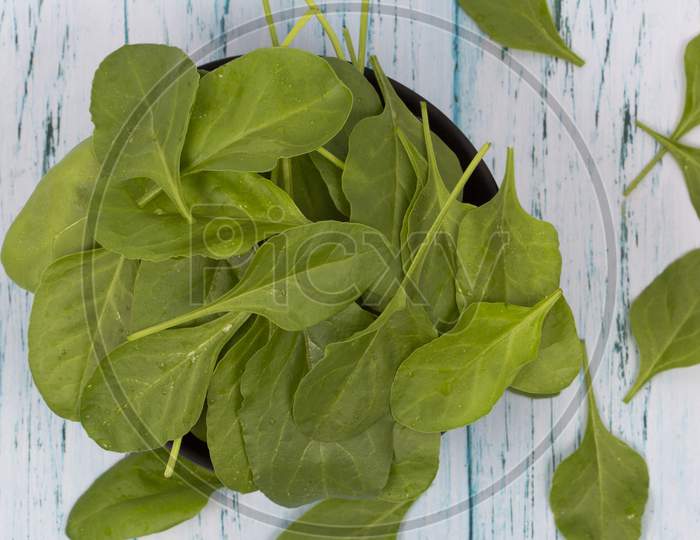 Fresh Green Spinach Leaves In Wooden Backgound