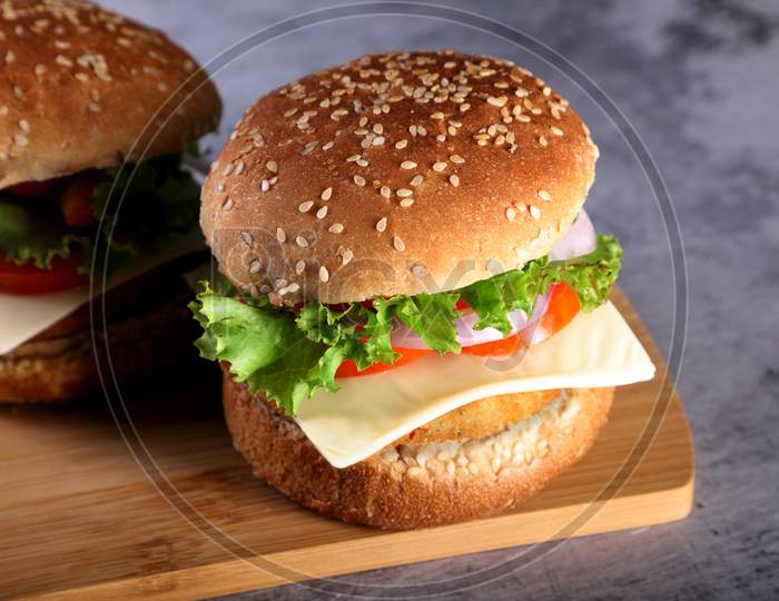Fast Food - Burgers On A Wooden Mat With Textured Background