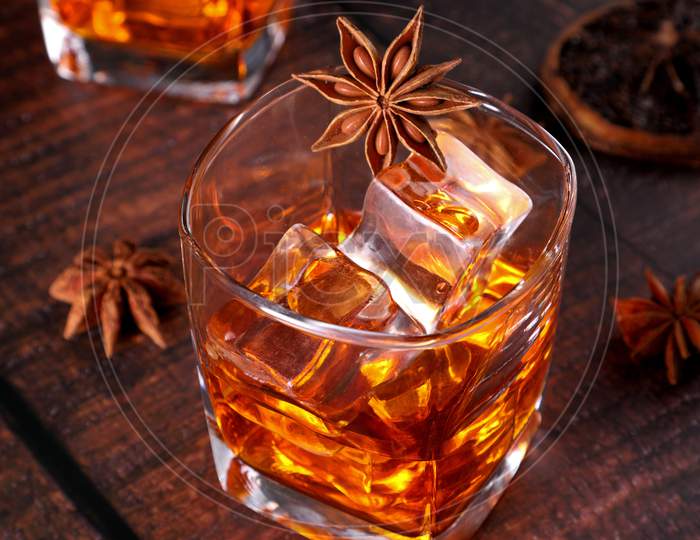 Whisky Rum Or Cold Drink With Star Anise And Dried Orange Slices On Wooden Table