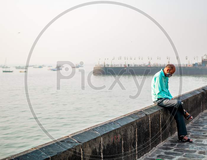 Unidentified Man Wearing A Face Mask Relating To Covid-19/Coronavirus Outbreak Near The Gateway Of India, A Famous Tourist Place In Mumbai