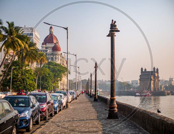 Cars Parked Near The Promenade Of Gateway Of India And Luxury Hotel Taj.