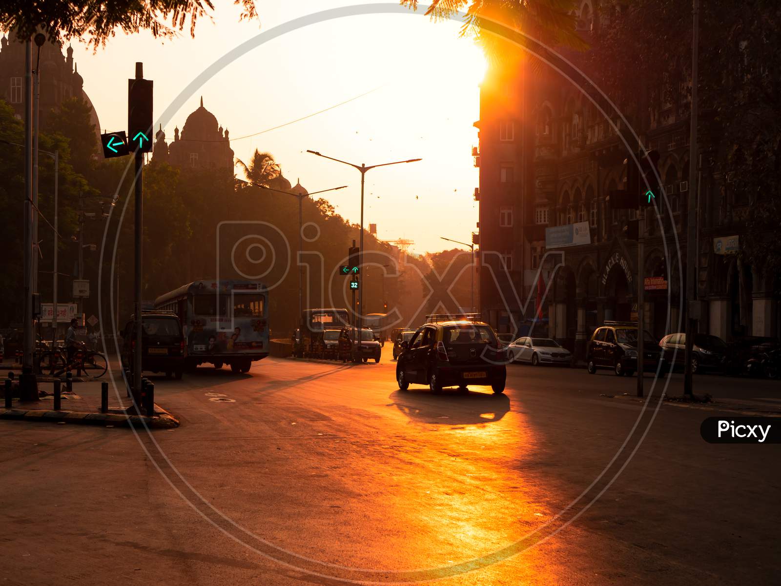 Silhouette Of Mumbai Taxi With Sun Rising In Background And Traffic Signal In Green On The Streets Of Mumbai