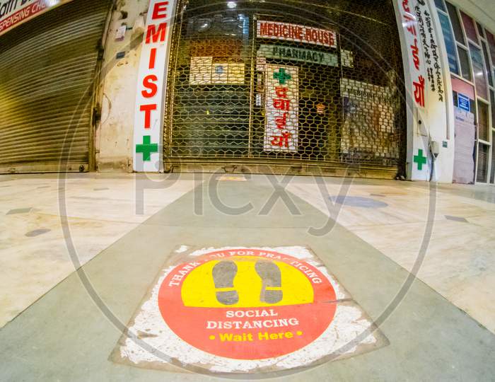 Low Wideangle Shot Of Floor Markings For Social Distancing In Front Of A Closed Chemist Shop As The New Wave Of Coronavirus Overwhelmes Healthcare In Delhi, India