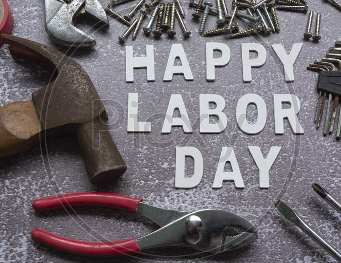 Happy Labor Day Text With Many Handy Tools On Grunge Grey Concrete Background