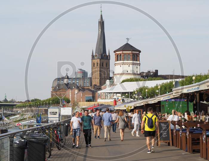 Duesseldorf, Germany - Circa August 2019: People On Rheinuferpromenade On The Bank Of River Rhein In The Altstadt (Old Town)