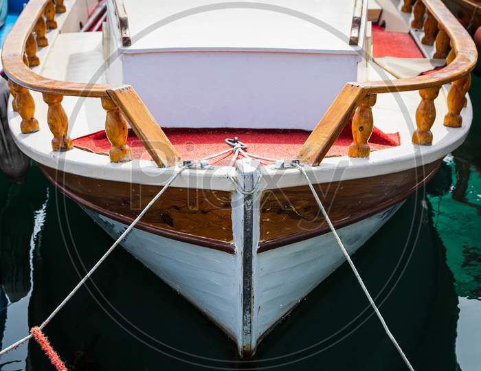 Wooden Side Of The Boat, Painted White And Brown, With A Beautiful Wooden Fence And Ropes Against The Background Of Sea Water
