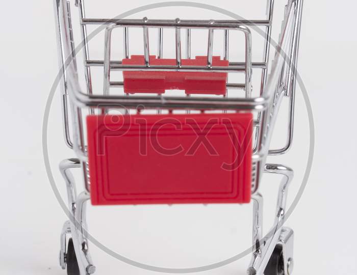 Empty Shopping Basket On Colorful Background. Shop Trolley At Supermarket. Sale, Discount, Shopaholism, Black Friday, Economy Concept. Consumer Society Trend. Sustainable Lives. Stock Photo