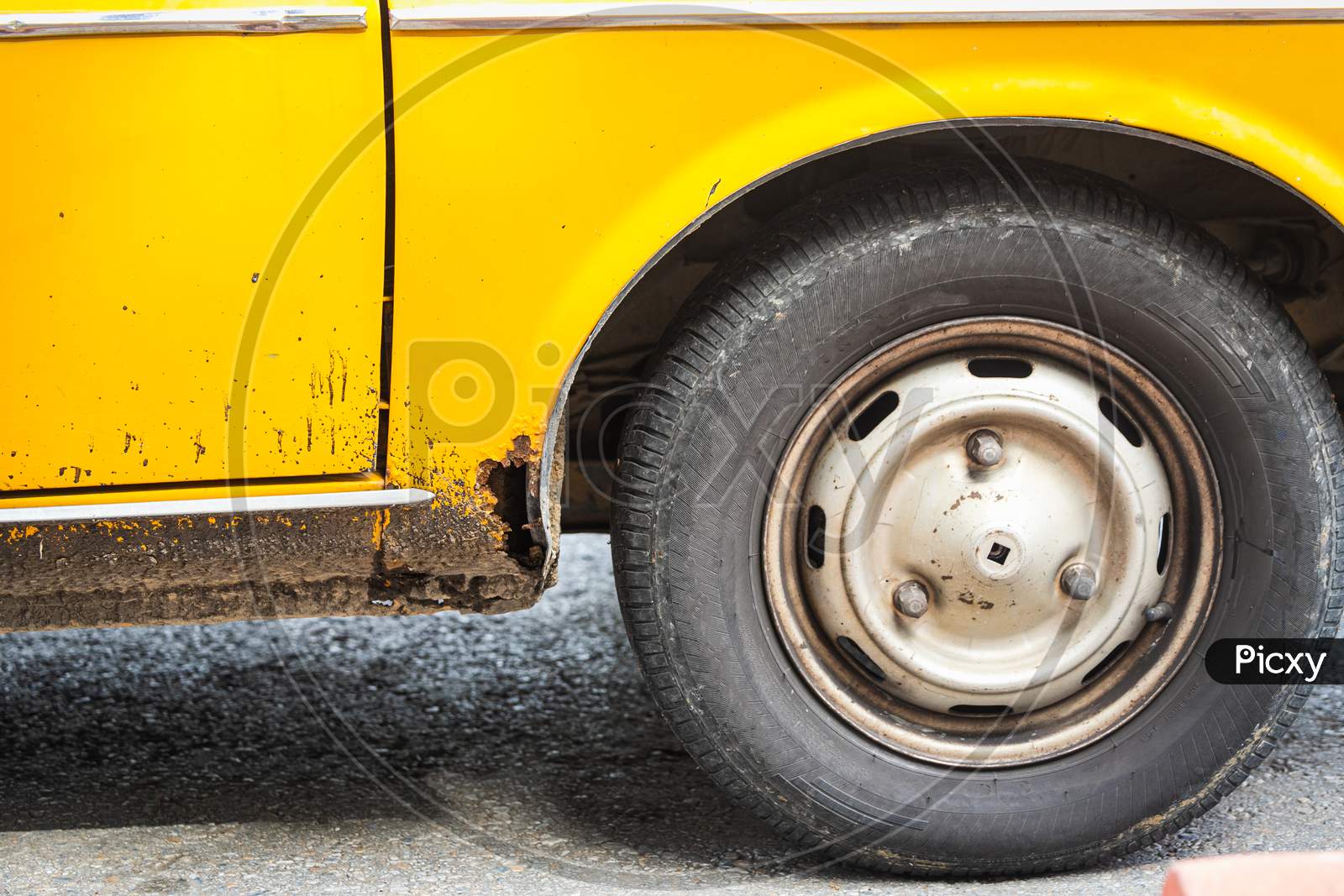 Car Wheel On An Old Yellow Rusted Car