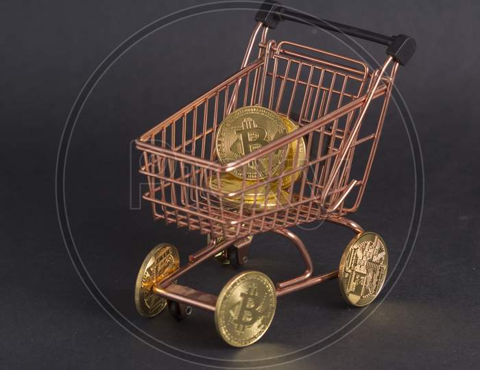 Bitcoins In Copper Shopping Cart. Black Background Stock Photo