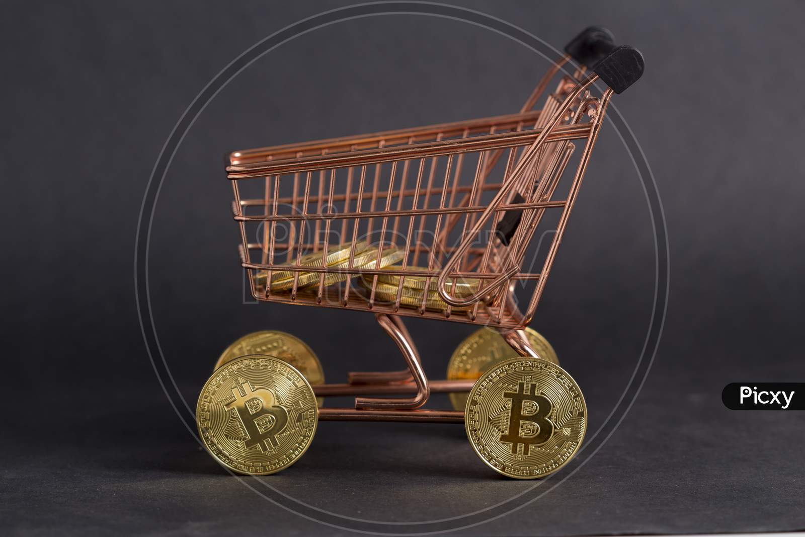 Bitcoins In Shopping Cart. Black Background Stock Photo