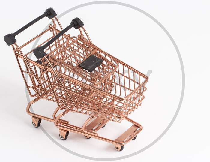 Empty Copper Shopping Basket On Colorful Background. Shop Trolley At Supermarket. Sale, Discount, Shopaholism, Black Friday, Economy Concept. Consumer Society Trend. Sustainable Lives. Stock Photo