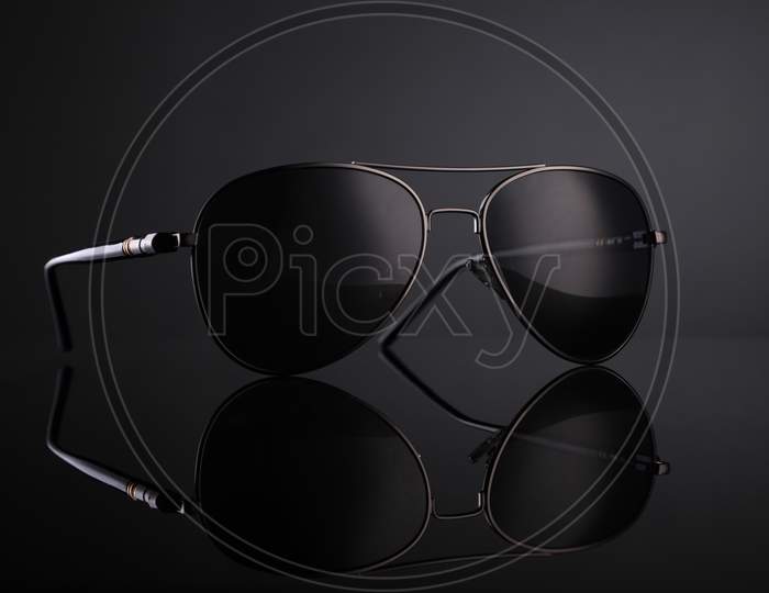 Black Aviator Sunglasses On Black Background With Reflection