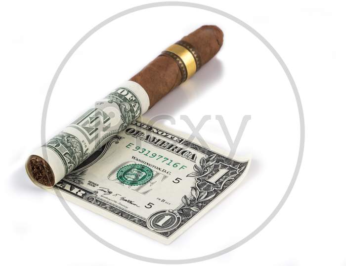 Cuban Cigar On A Rolled Dollar On The White Background Stock Photo