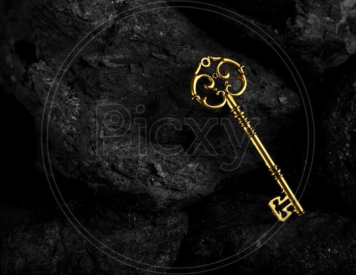 Golden Antique Key On Black Stone Background