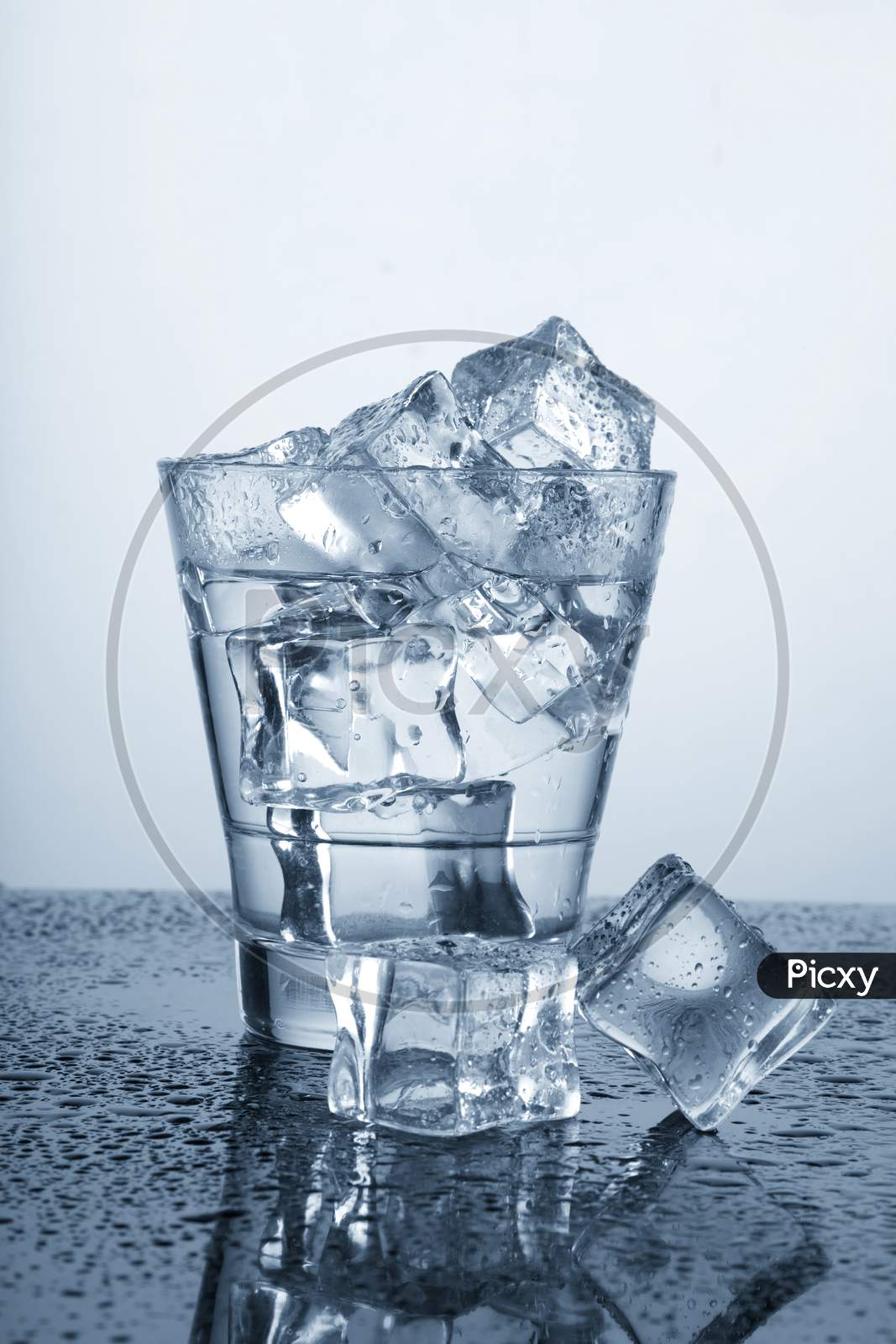 Chilled Glass Of Water With Ice Cube And Water Drops