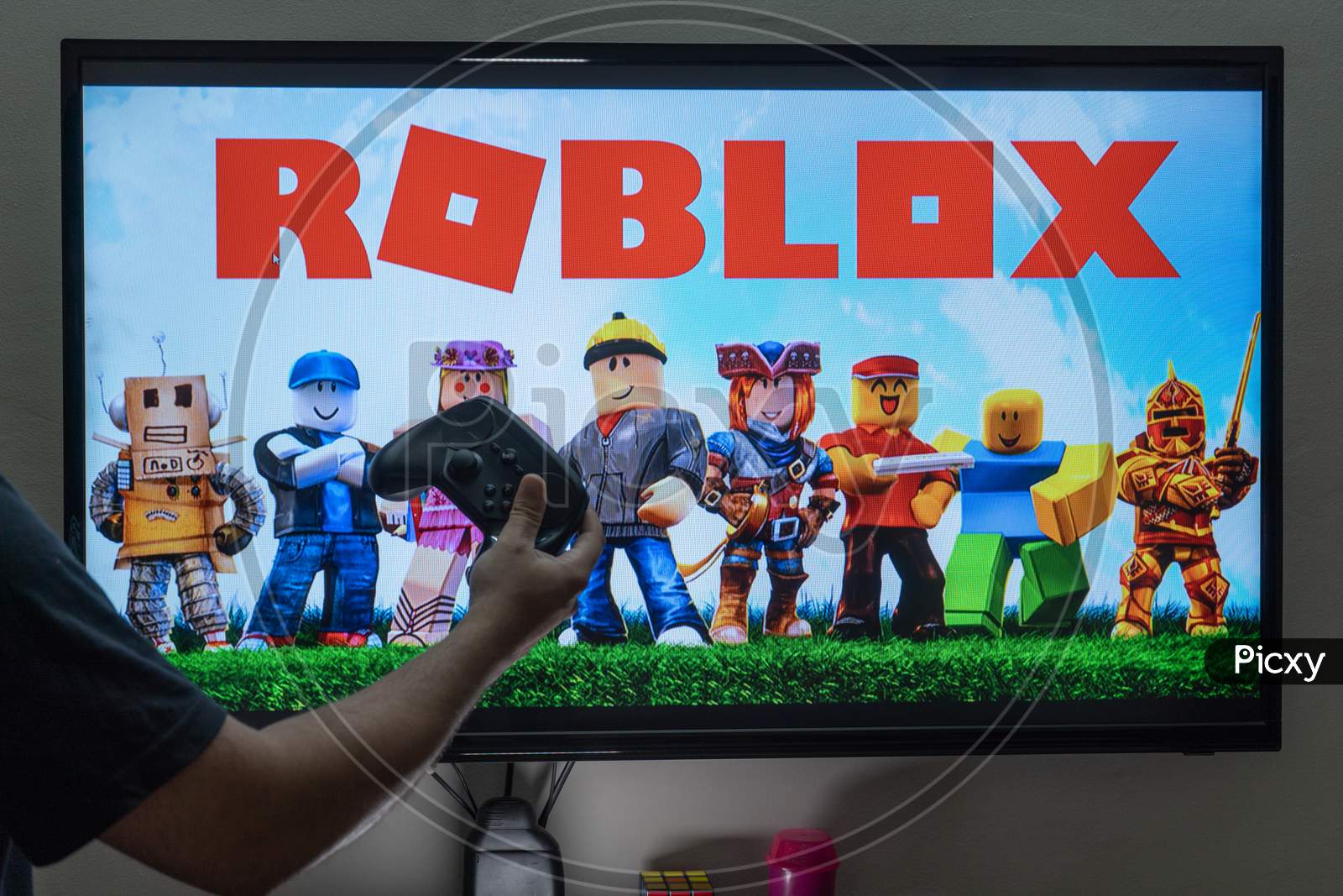 Image Of Man With A Controller Standing In Front Of A Pc Console Tv Screen With A Steam Controller Playing Popular Free To Play Game Roblox Et303787 Picxy - how to play roblox on pc with controller