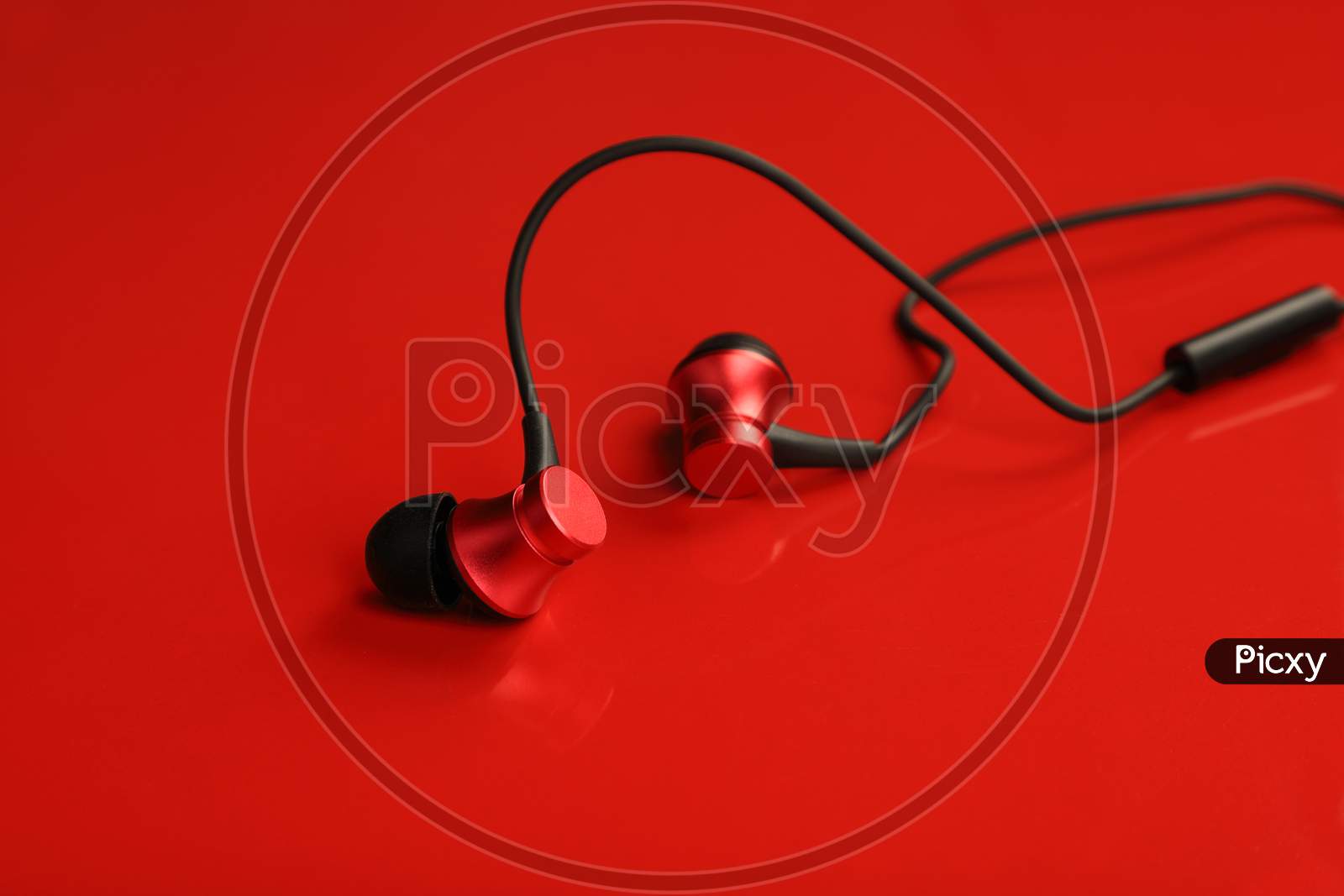 Red Colored Wired Earphone On Red Background