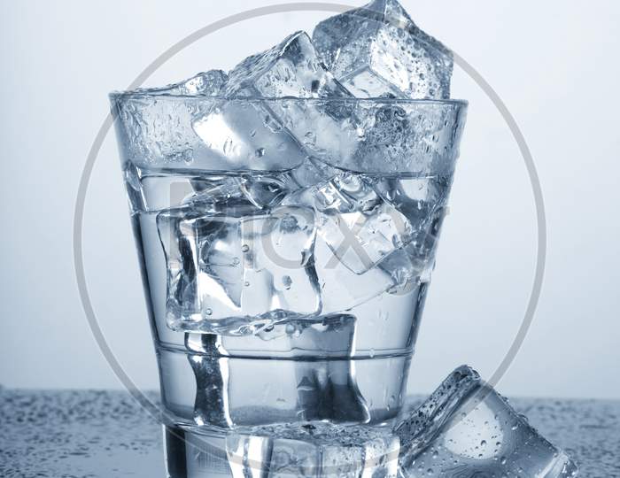 Chilled Glass Of Water With Ice Cube And Water Drops
