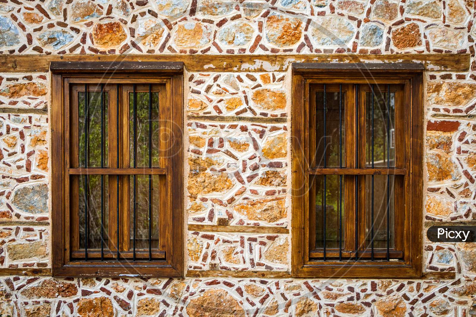 Close-Up Wall Of A Stone House With Wooden Windows And Shutters. Old European Architecture