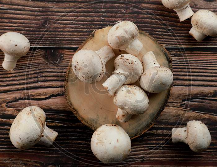 Fresh Uncooked Organic Button Mushrooms In A Wooden Tray