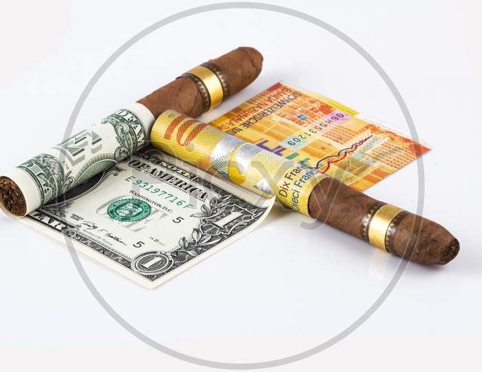 Cuban Cigar On A Rolled Dollar And Rolled Euro On The White Background Stock Photo