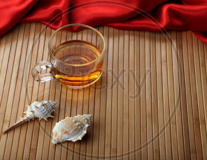 Cup Of Tea On Wooden Table Mat With Sea Shells