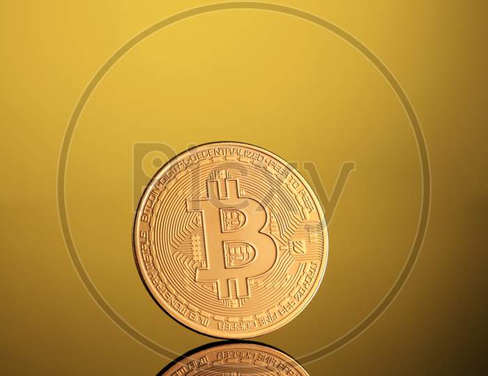 Golden Bitcoin Money Currency On Gold Background With Reflections