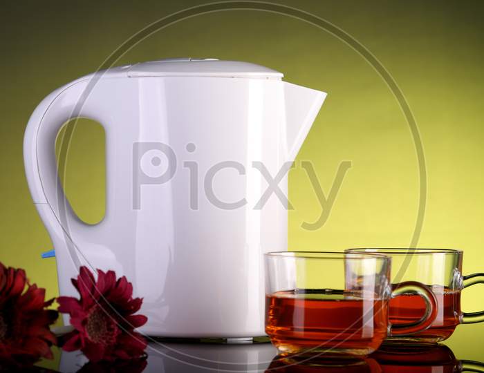 Electric Kettle And Two Tea Cups With Flowers