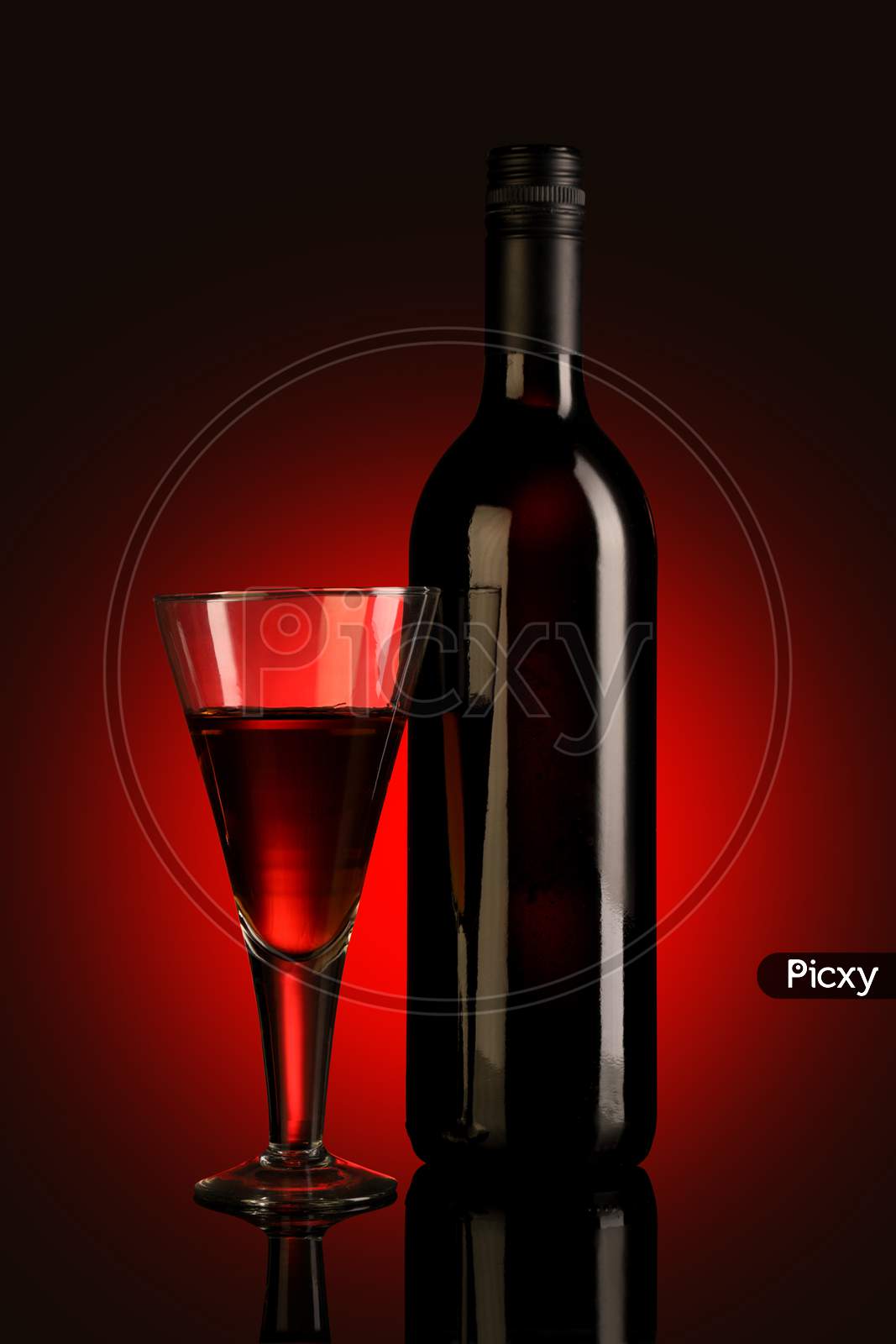 Red Wine Glass And Bottle On Red Background