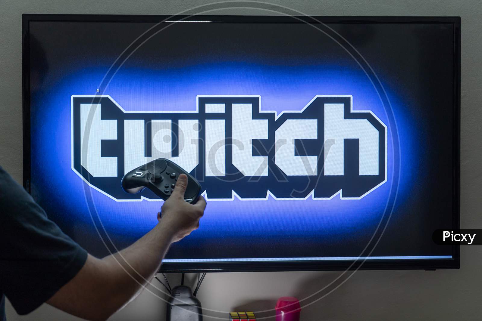 Man Holding A Steam Remote In Front Of A Pc Console Screen Showing Twitch Streaming Platform Where People Are Streaming Fulltime To Earn Money