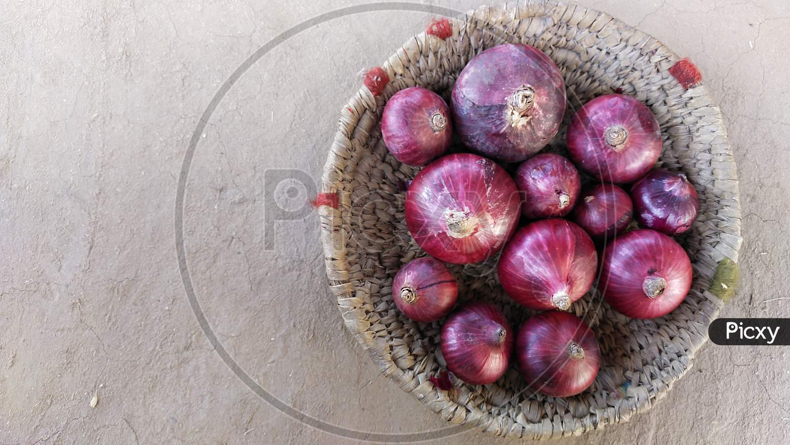 Red colour onions in a handmade basket